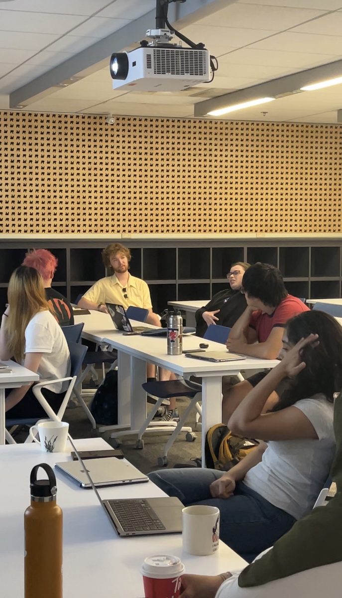 Students discussing science around a laptop